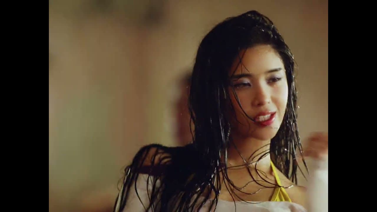 KATSEYE 'Hootie Frutti' MV capture: a member with wet hair looks off camera in a warmly lit room
