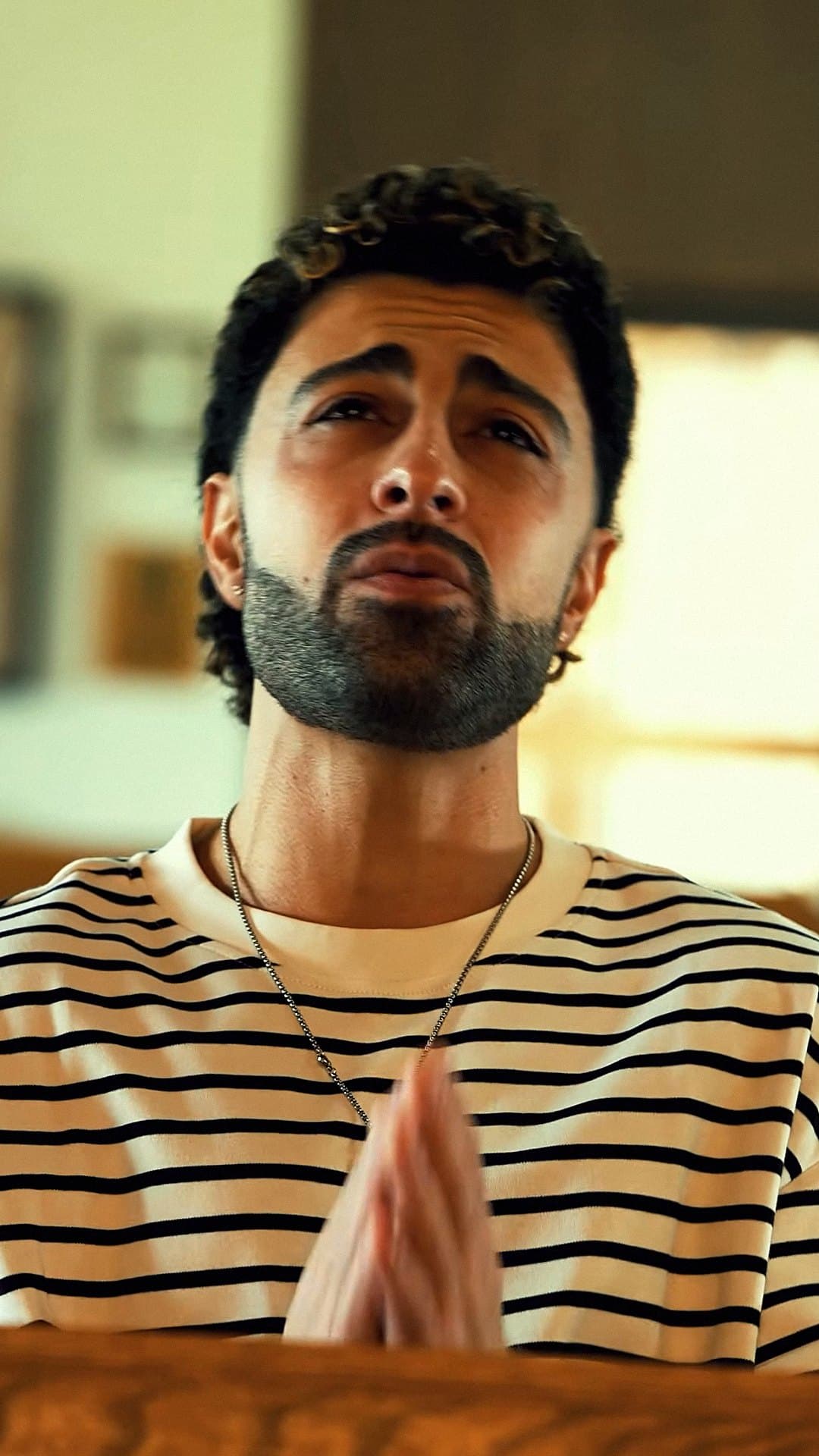Lexnour, in a striped T-shirt, lifts his face in prayer in the video for 'God I Need You'