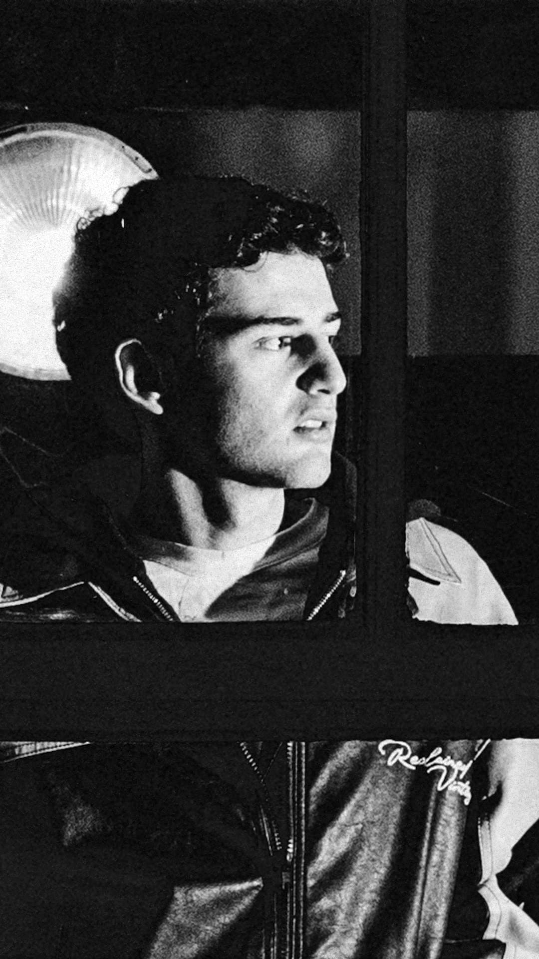 DA TI in a leather jacket looks out of a dark window beside a round lamp, in the black-and-white photograph on the cover of his single 'Take Me There'