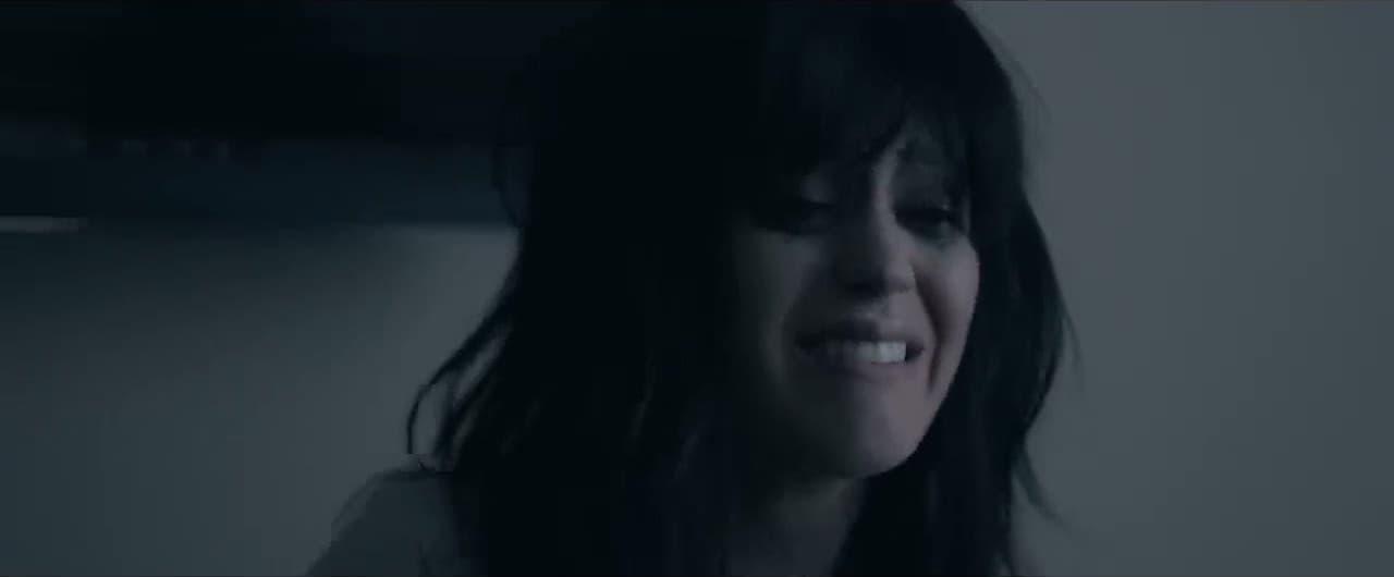 Katy Perry 'The One That Got Away' MV capture: Katy Perry with black hair and bangs looks down, tearful, in grey light